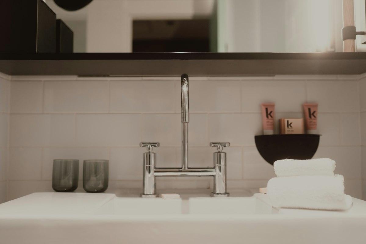 Glass of tap water and toothbrush on a bathroom counter