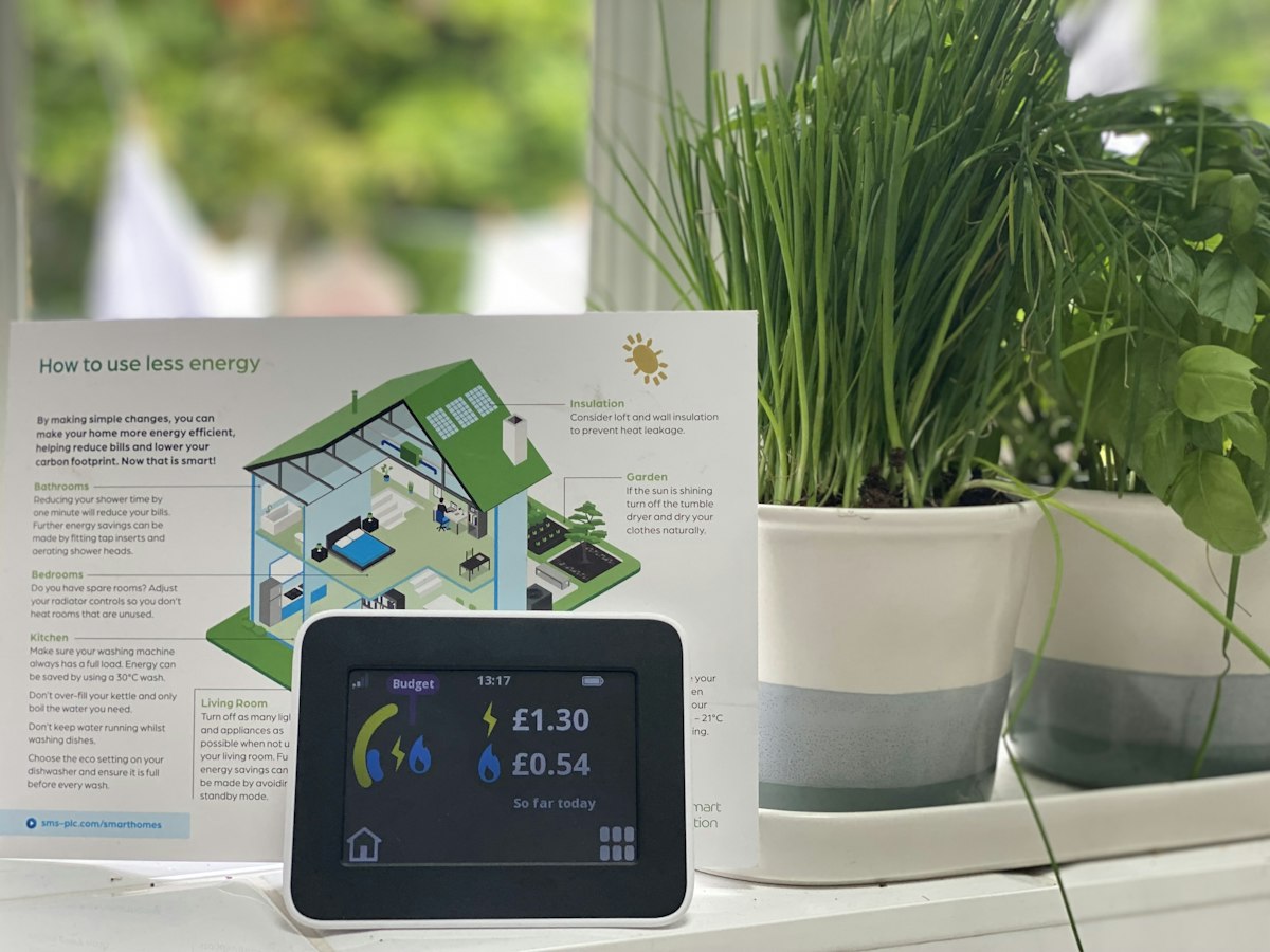 Consumer indoor air quality monitor displaying readings on a living room shelf
