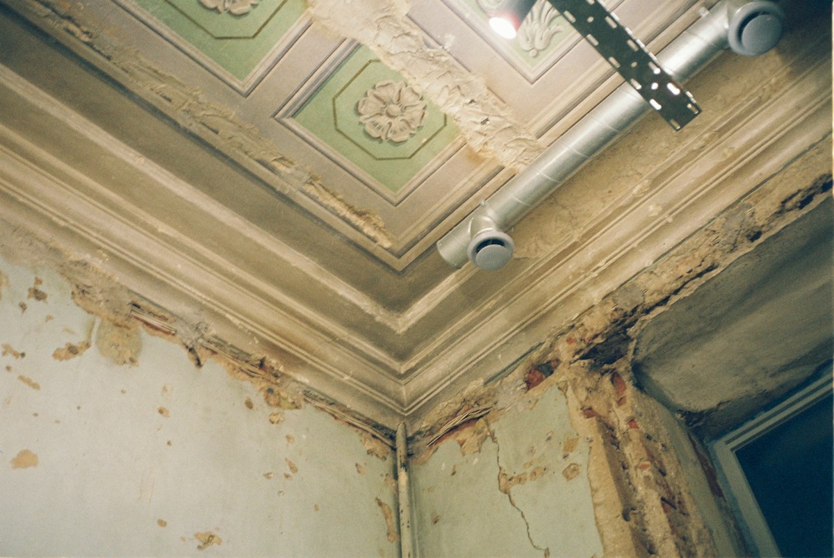 Mold spots on a damp wall corner near an air vent