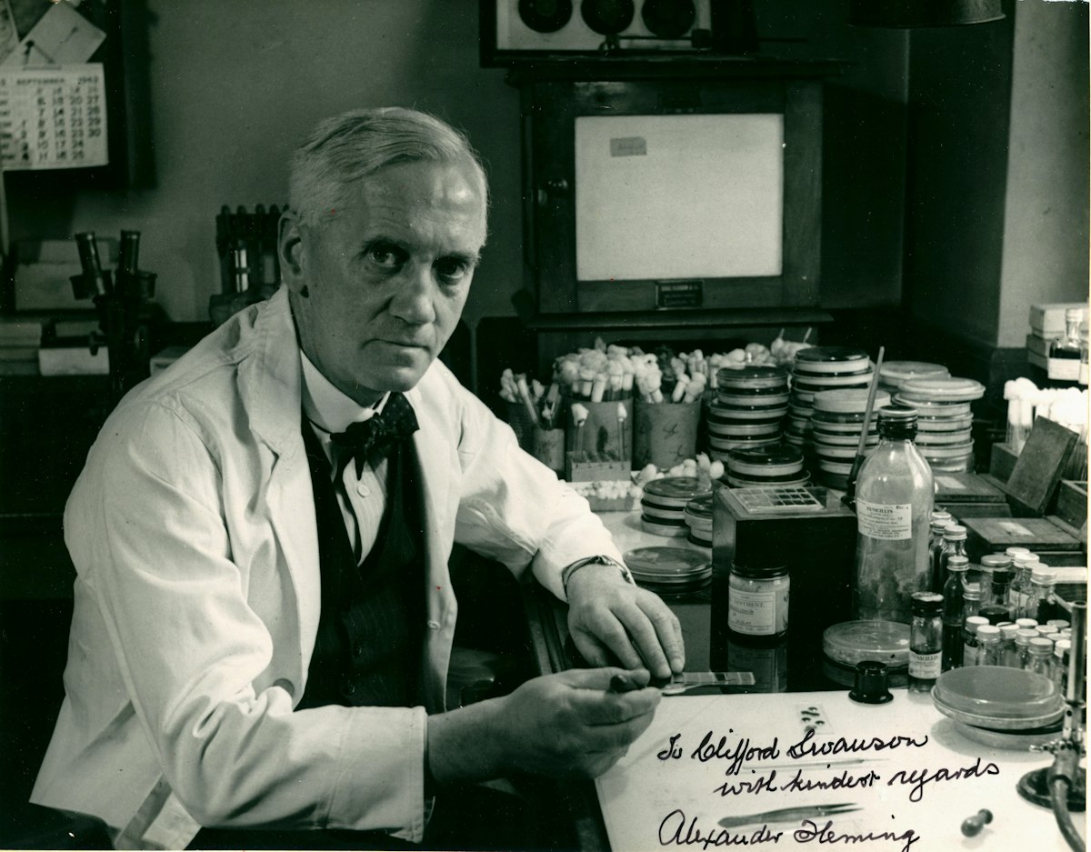 Scientist in lab coat with petri dishes and equipment