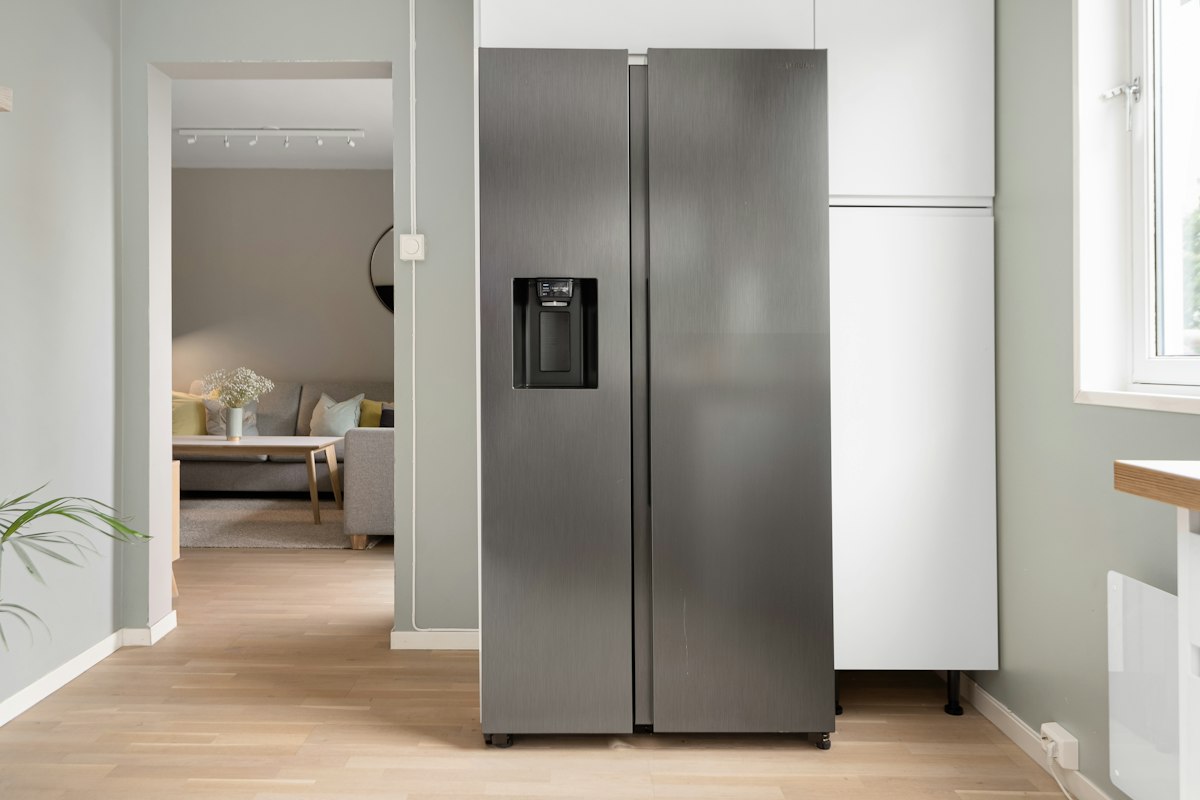 A refrigerator in a kitchen next to a window