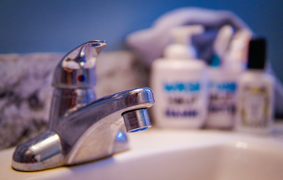 A chrome faucet on a white bathroom sink
