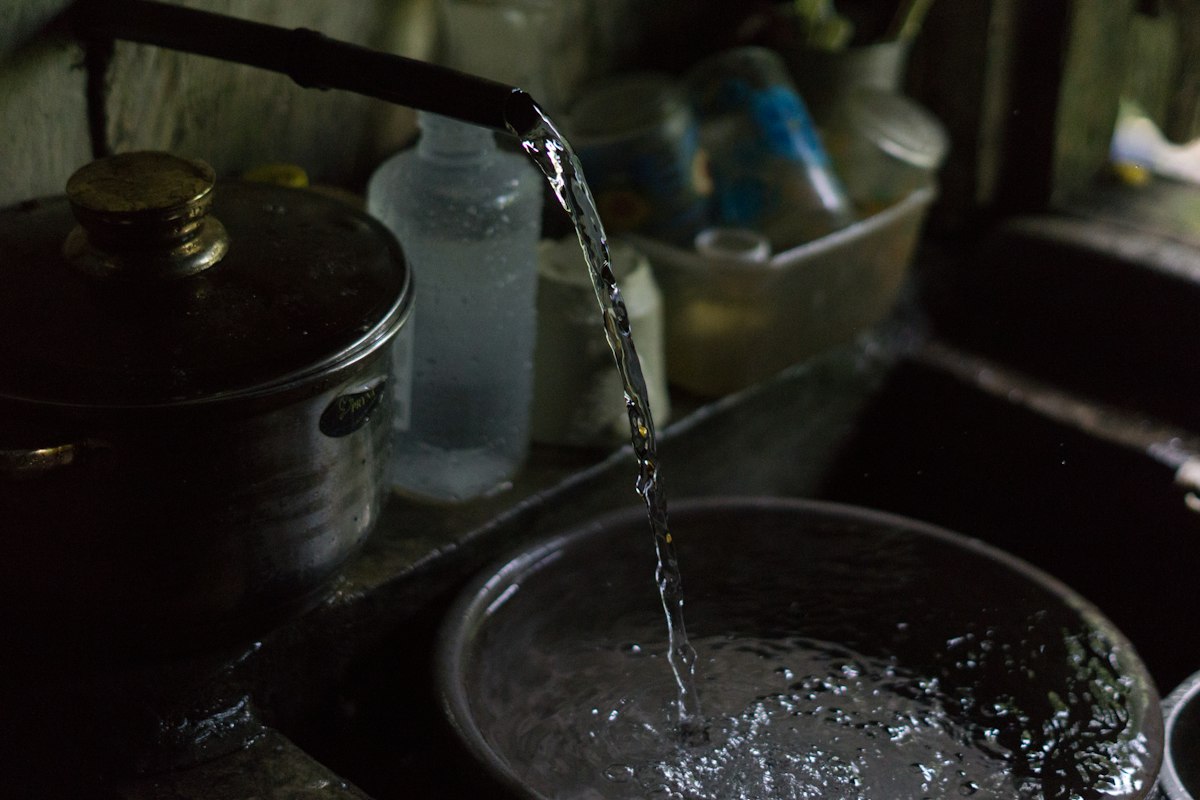 Water flowing into a metal bowl from a faucet