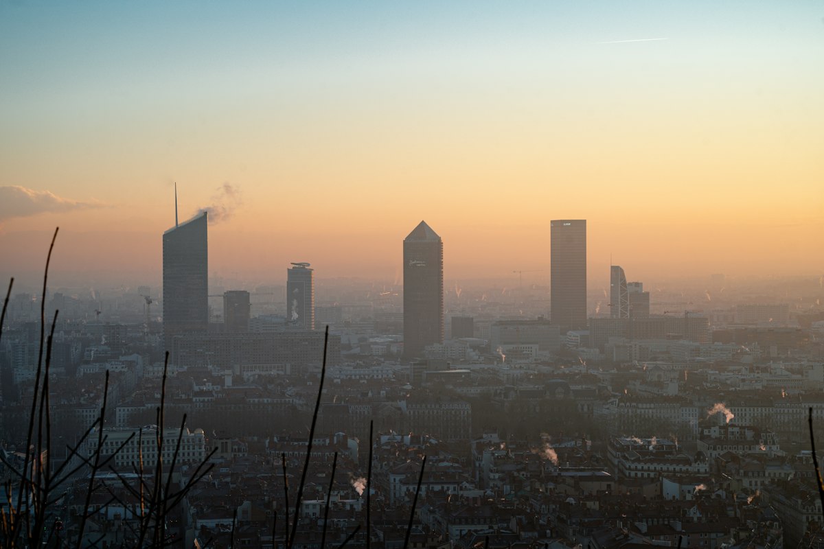Misty cityscape with modern skyscrapers at sunrise